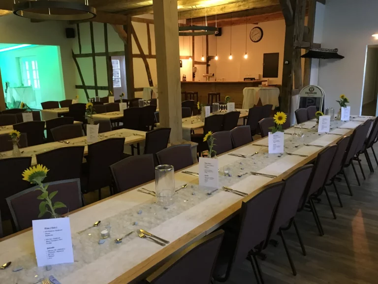 Die Tische stehen in einer Reihe und sind mit Sonnenblumen dekoriert