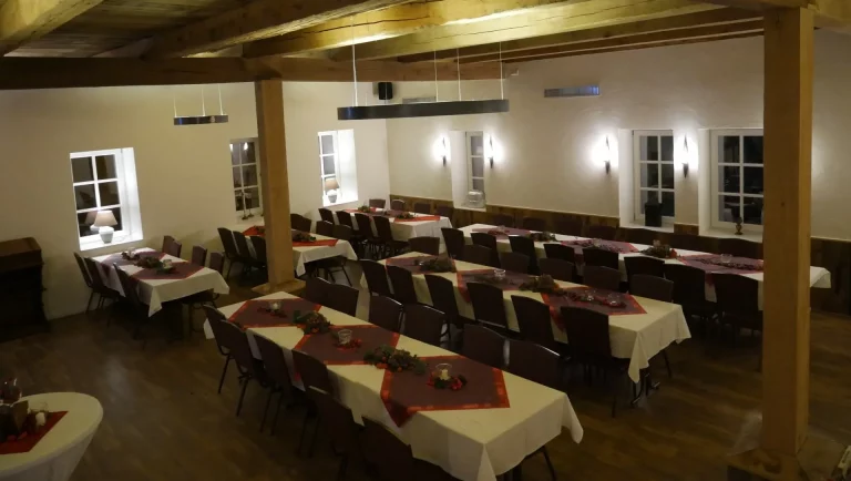 Die Tische sind mit roten und weißen Tischdecken eingedeckt und stehen in Reihen gerade nebeneinander