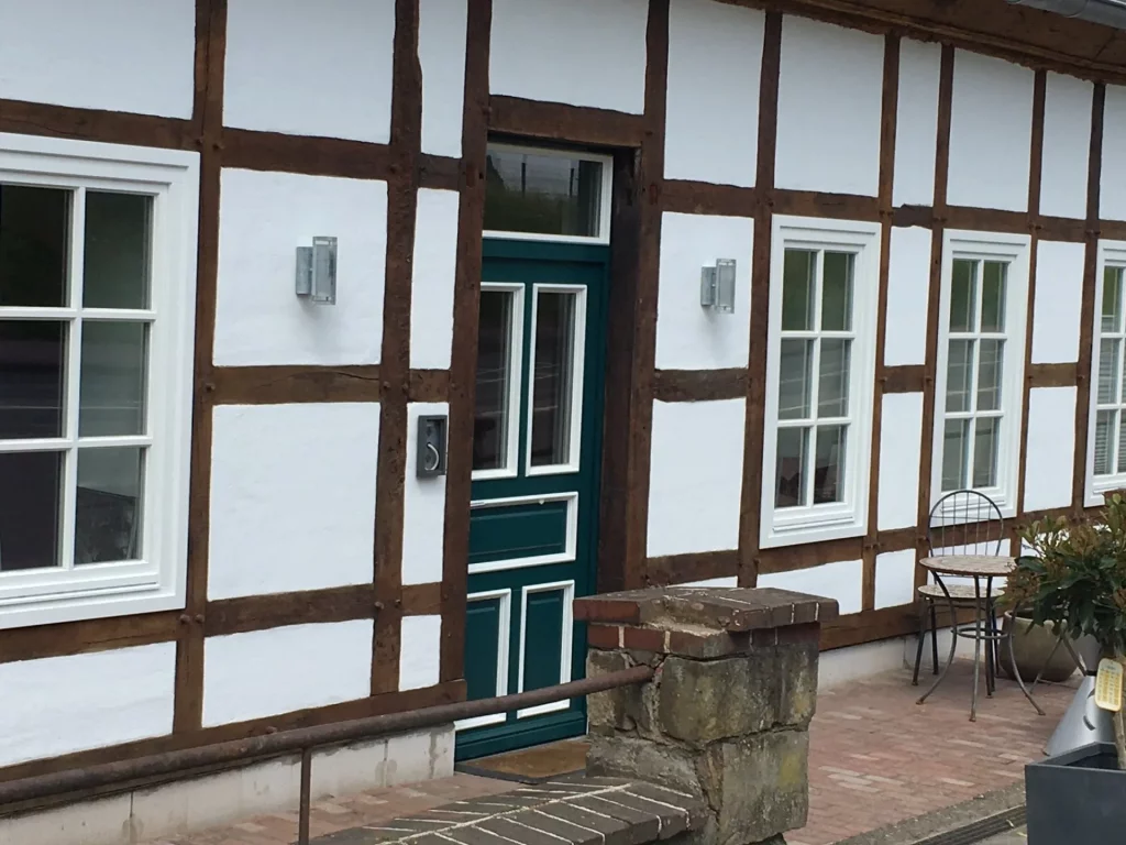 Es gibt einen Nebeneingang mit grüner Holztür, der in den Partyraum führt.