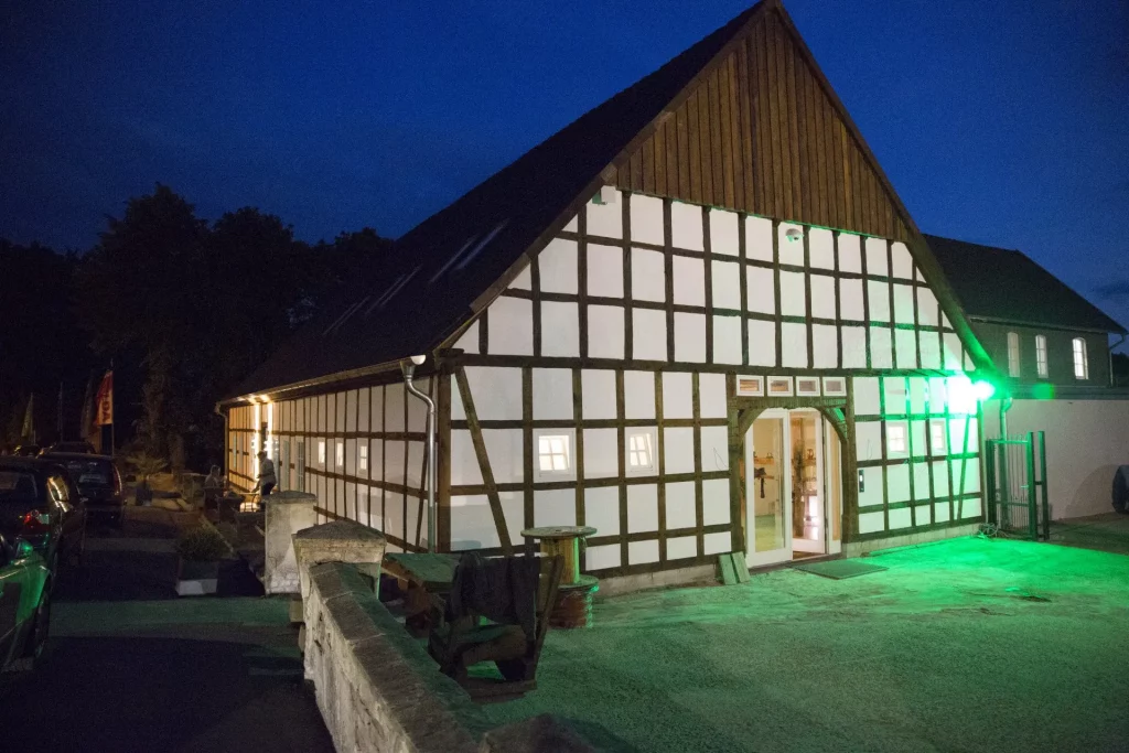 Das Gebäude ist ein altes Fachwerkhaus mit großem Dielentor, das heute als Eventlocation dient.